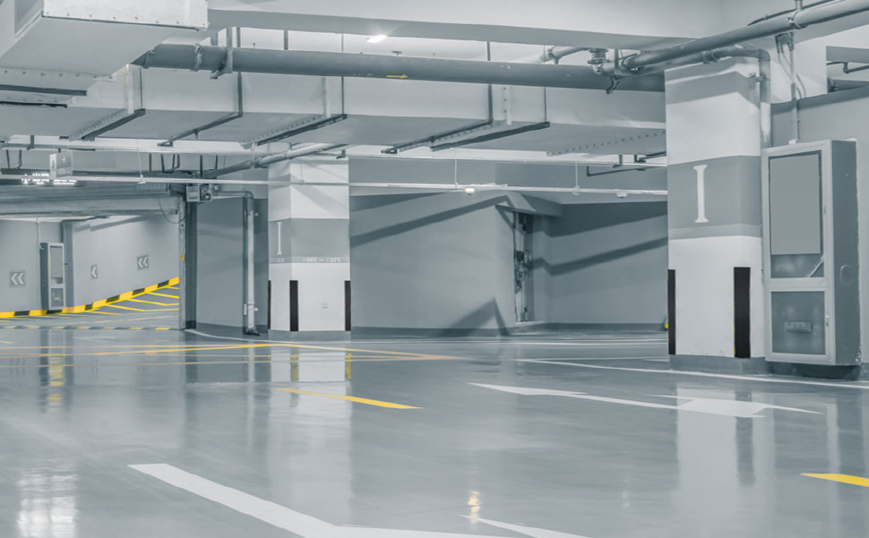 An empty parking garage with yellow arrows.