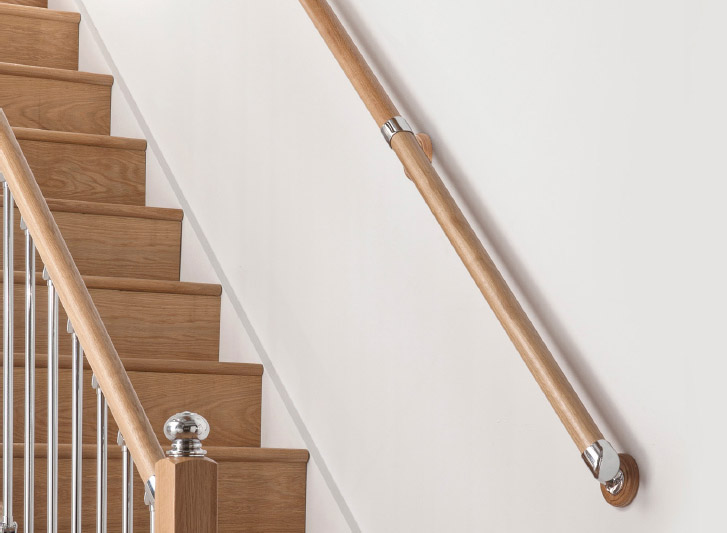 A wooden stair rail with a metal handrail and Wood Corner Guards.