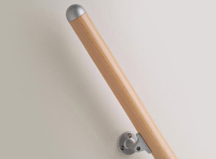 A wooden handrail mounted on a white wall.