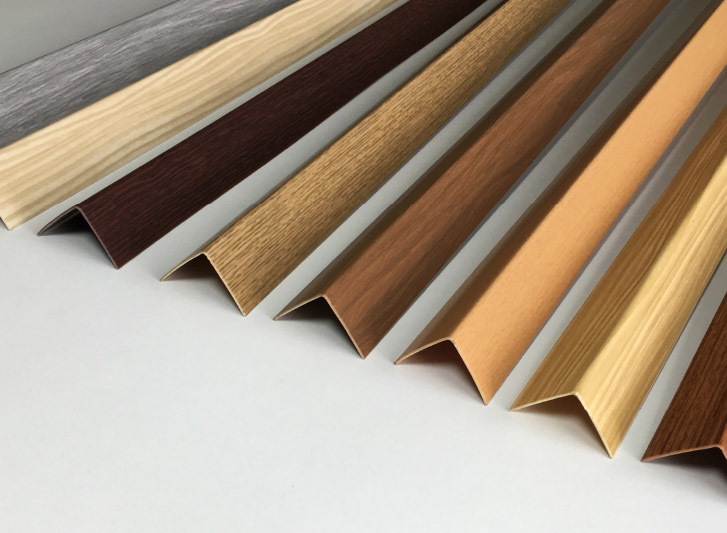 A row of different colored woods on a white surface featuring Wood Corner Guards.