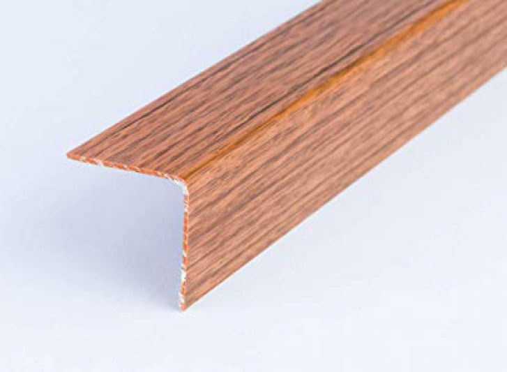 A close up image of a wooden trim on a white surface, featuring Wood Corner Guards.